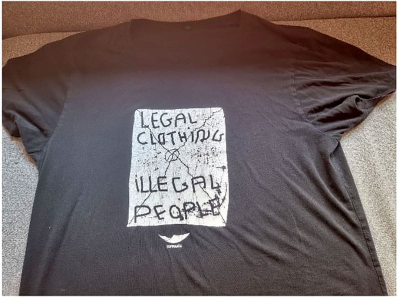 Svart t-shirt med texten "Juridiska kläder, illegala människor"